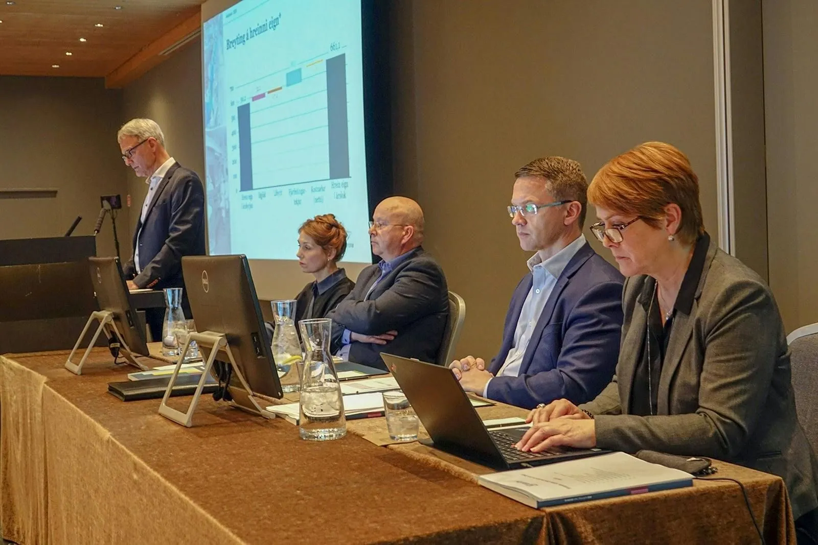 Ræðumaður í ræðustól og fulltrúar við háborð á ársfundi Gildis 2020